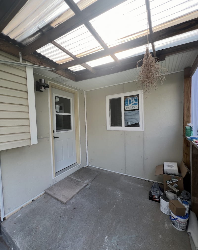 Finished enclosed porch with new entry door, window, and clean siding panels