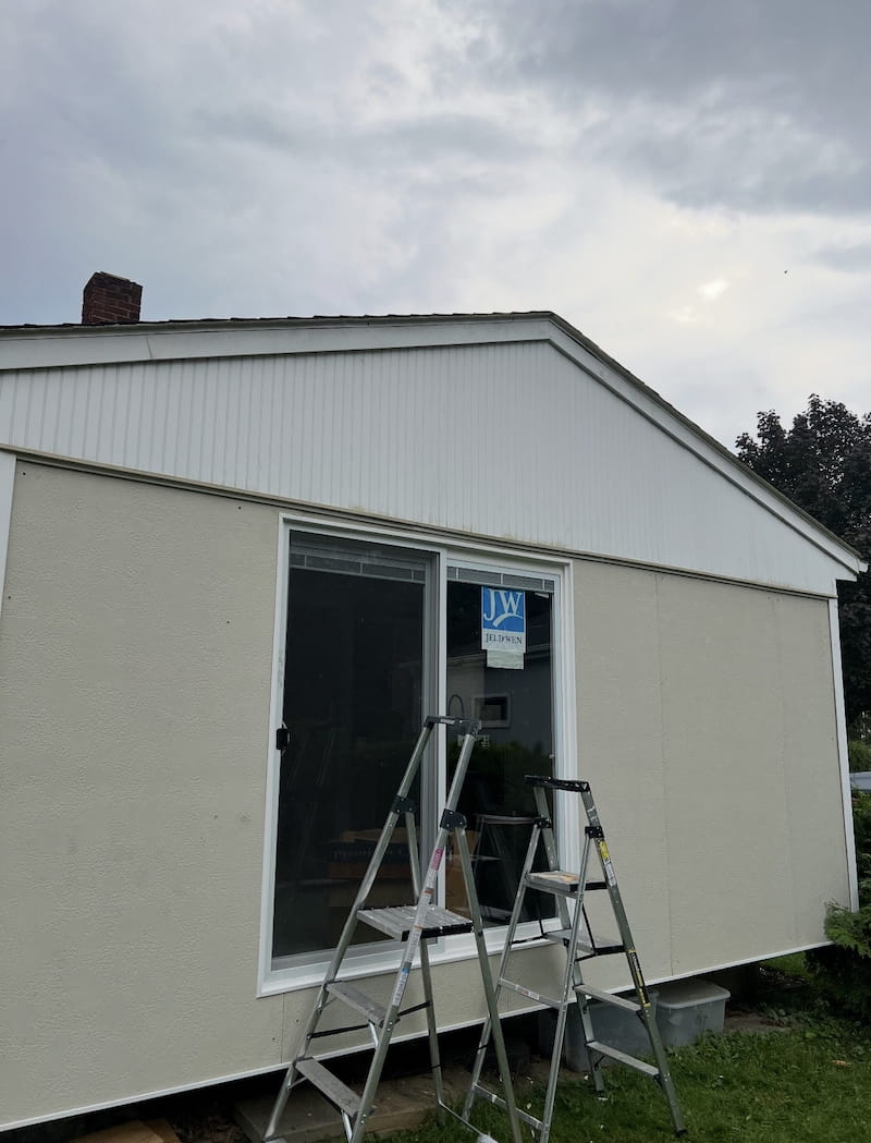Exterior view of finished porch showing new sliding door and panel siding