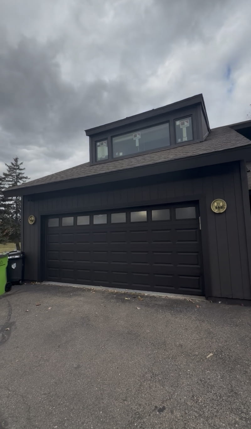 Front view showing matching dark garage door and clean exterior