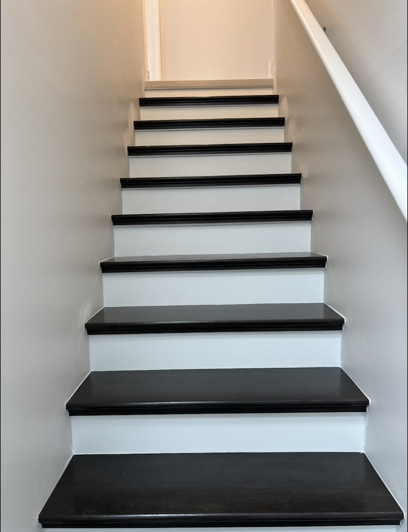 Custom dark espresso-stained stair treads with crisp white painted risers